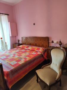 a bedroom with a bed and a chair next to a desk at Casa di Rosa in Cureggio