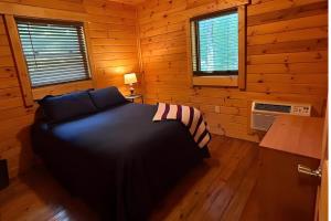 a bedroom with a bed in a wooden cabin at Charlie Long Cabin - Active Heroes in Shepherdsville
