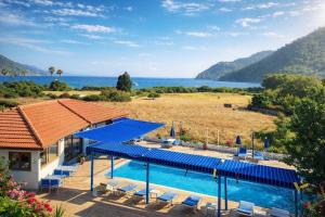a house with a swimming pool with a view of the ocean at Emir Palas Hotel in Ekincik