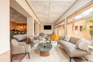 a lobby with couches and chairs and a table at Kenzi Azghor in Ouarzazate