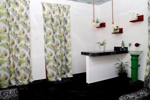 a bar in a room with curtains and plants at Riverside Bliss Cottage in Demodera