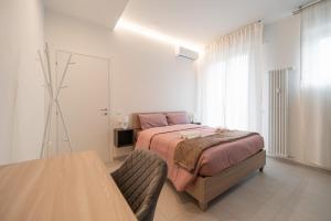a bedroom with a bed and a table in it at Alloggio Viola - Gionic Apartments Bologna in Bologna