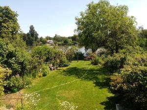a garden with a river in the background at Pension Pichelsdorf in Berlin