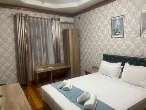 a bedroom with a bed with towels on it at GLOBUS Avenue Hotel in Yakkasaray