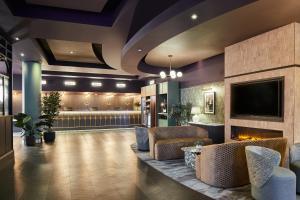 a lobby with a waiting area with chairs and a tv at Leonardo Hotel Dublin Parnell Street in Dublin