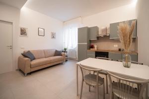 a kitchen and living room with a couch and a table at Alloggio Viola - Gionic Apartments Bologna in Bologna