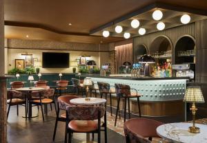 a restaurant with tables and chairs and a bar at Leonardo Hotel Dublin Parnell Street in Dublin