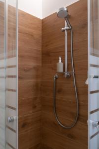 a shower in a bathroom with a wooden wall at Alloggio Viola - Gionic Apartments Bologna in Bologna