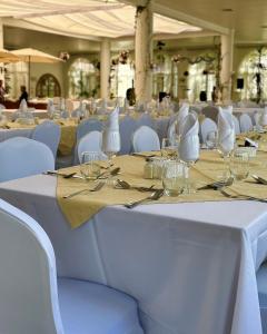 a long table with white chairs and glasses on it at Resort Termas de Panimávida - Hotel & Spa in Panimávida