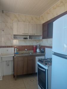 a kitchen with a sink and a stove top oven at Casa temporada in Arraial do Cabo