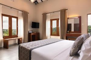 a bedroom with a large white bed and windows at Oak Ray Sky Terrace in Kandy