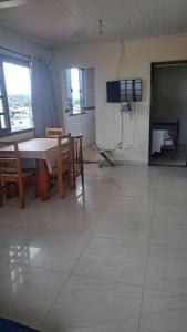 a living room with a table and chairs and a television at Casa temporada in Arraial do Cabo