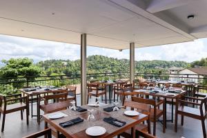 a restaurant with wooden tables and chairs and a balcony at Oak Ray Sky Terrace in Kandy