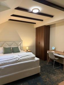 a bedroom with a white bed and a desk at Amfora Novi Sad in Pasuljište