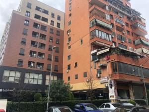 a tall building with cars parked in front of it at Center Luxury Apartment in Tirana