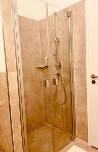 a shower with a glass door in a bathroom at Brandmayerhof in Oberding