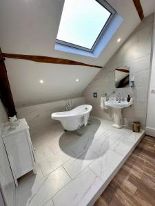 a bathroom with a sink and a tub and a skylight at Studio 3 des Remparts à 5 mins de Charleville-Mézières in Warcq +15 photos