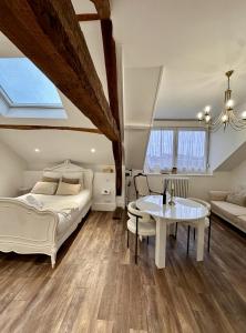 a bedroom with a bed and a table and a couch at Studio 3 des Remparts à 5 mins de Charleville-Mézières in Warcq
