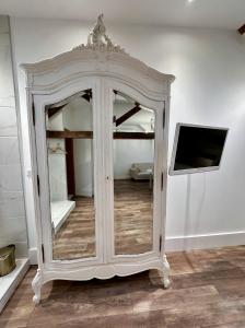 a white cabinet with a tv in a room at Studio 3 des Remparts à 5 mins de Charleville-Mézières in Warcq
