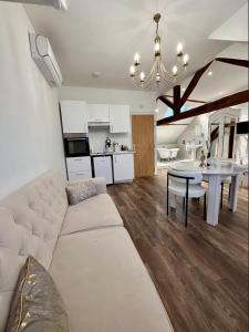 a living room with a white couch and a table at Studio 3 des Remparts à 5 mins de Charleville-Mézières in Warcq