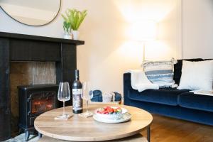 a living room with a table with a bowl of fruit and wine glasses at Northern Hideaways, Eider Cottage, Seahouses in Seahouses