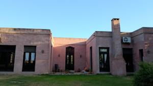 an old building in the middle of a field at Los Patios Haras El Malacate in A. de la Cruz