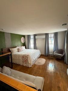 a bedroom with a bed and a couch in it at PASEO REAL HOTEL BOUTIQUE in Uruapan del Progreso