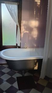 a bath tub in a bathroom with a window at Los Patios Haras El Malacate in A. de la Cruz +27 photos