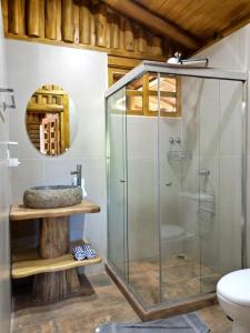 a glass shower in a bathroom with a sink at Cabañas Samara Buenavista in Sámara +21 photos