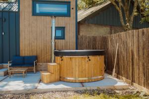 a hot tub in a yard next to a fence at Tiny Bali spa house in Menaldum