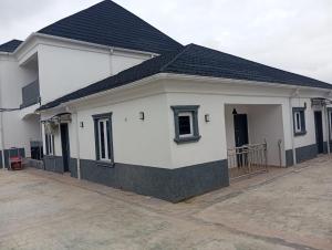 a white house with a black roof at Dipo Apartments in Badore