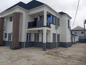 a large white house with a balcony in a parking lot at Dipo Apartments in Badore