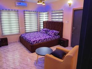 a bedroom with a bed and a table and a couch at Dipo Apartments in Badore