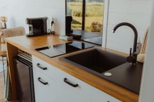 a kitchen with a sink and a stove top oven at Tiny Bali spa house in Menaldum +6 photos