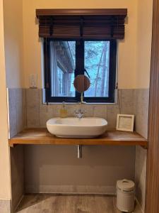 a bathroom sink with a mirror and a window at Toad Hall in Grimston +52 photos