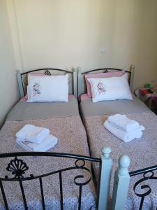 two beds in a room with towels on them at Livanos Apartments in Neapoli Voion