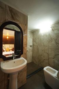 a bathroom with a sink and a tub and a mirror at My Trip Houseboats in Alleppey