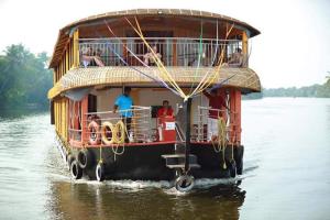 a boat with people on it in the water at My Trip Houseboats in Alleppey