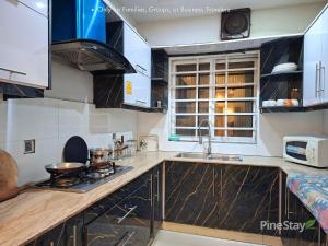 a kitchen with a sink and a stove top oven at Pine Stay Premium 3 Bedroom Furnished Family Home in Lahore
