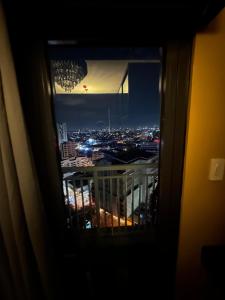 a view of a city at night from a window at Sunbeam - Lush Residence in Manila