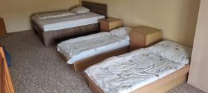 three beds in a room with boxes in it at Apartmán u Milana v Pisku in Písek