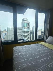 a bedroom with a view of a city from a window at Sunbeam - Lush Residence in Manila