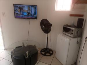 a room with a fan and a tv on the wall at Matte Guest House in Potchefstroom