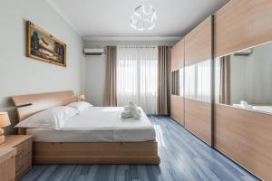 a bedroom with a large bed and a large mirror at The Old-Clock Apartment by PikHost in Shkodër