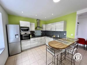 a kitchen with a wooden table and a refrigerator at La calm in Villardonnel