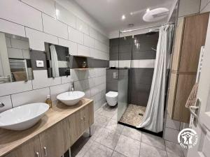 a bathroom with two sinks and a shower and a toilet at La calm in Villardonnel