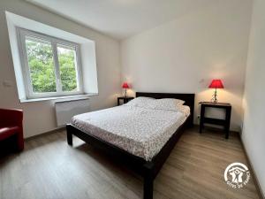 a bedroom with a bed and a window at La calm in Villardonnel