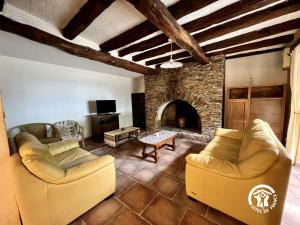 a living room with two couches and a stone fireplace at Domaine de la calm in Villardonnel