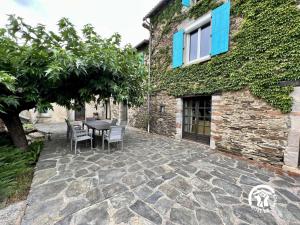 a patio with a table and chairs next to a building at Domaine de la calm in Villardonnel