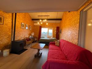 a living room with a red couch and a table at Equi Guidance Studio in Wapenveld
